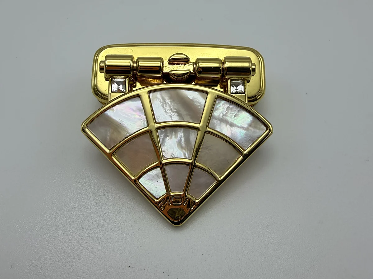Fan-shaped decorative metal sample illustrating a sculpted surface